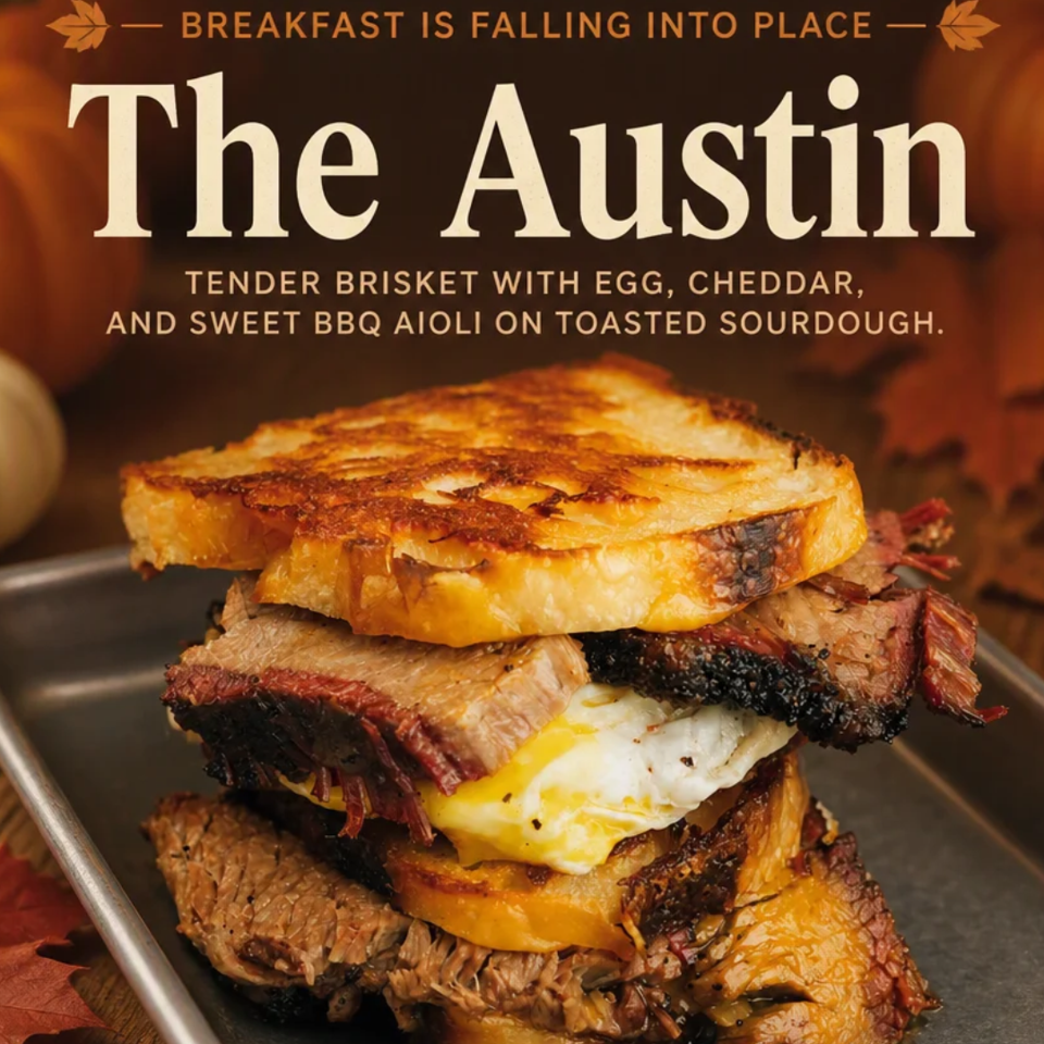 Stacked Austin breakfast sandwich with brisket, fried egg, cheddar, and toasted sourdough, promoted as a weekend special.