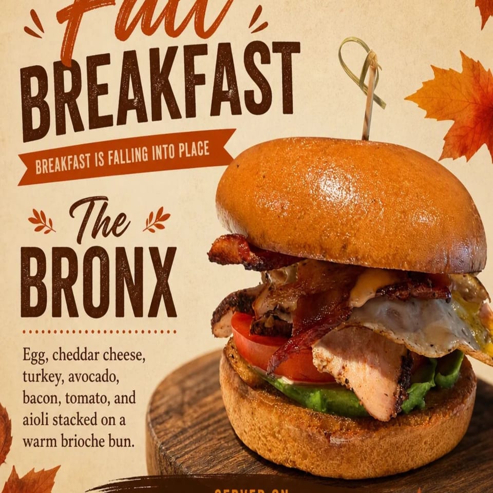 Promotional graphic for The Bronx fall breakfast sandwich with egg, cheddar, turkey, avocado, bacon, tomato, and aioli on a brioche bun.